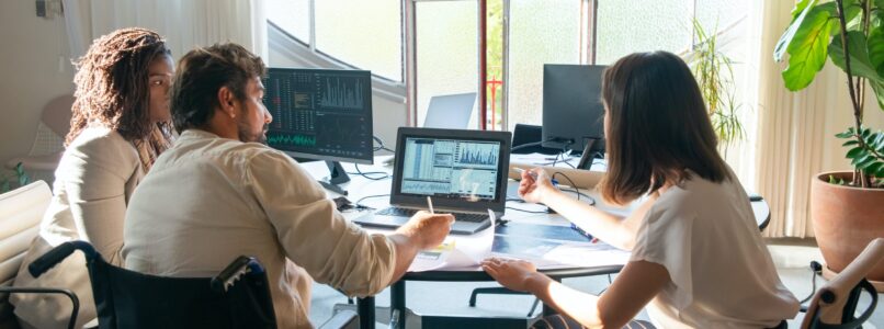 three employees working together at a desk