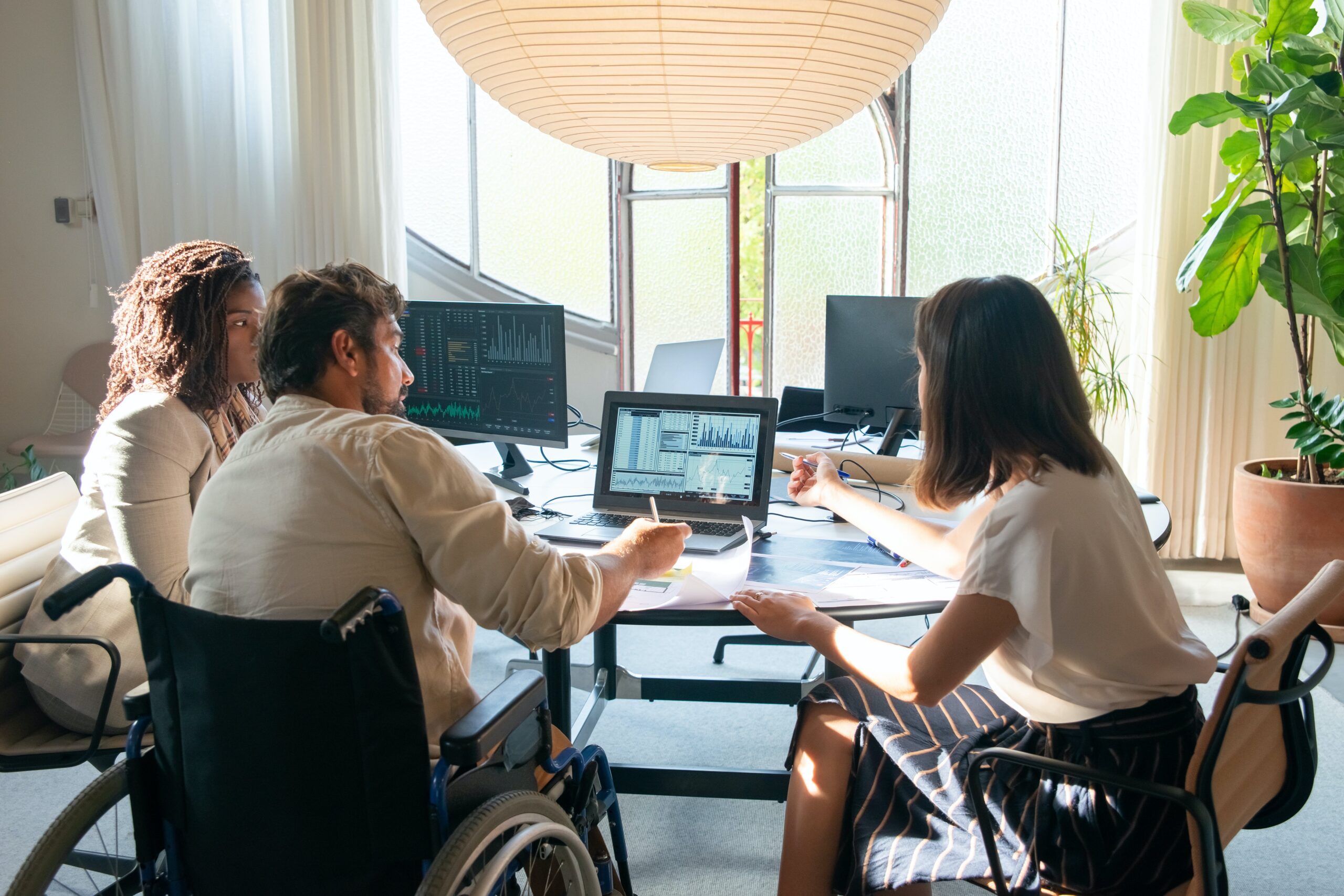 three employees working together at a desk