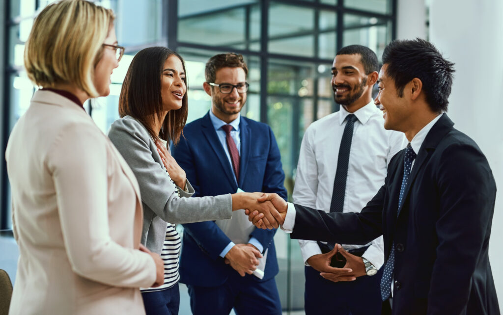 Team, Business People And Shaking Hands For Welcome, Introduction Or Greeting In Office